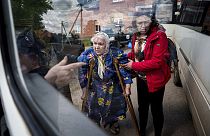 Menschen helfen Liudmila, 85, nach ihrer Evakuierung aus Wovtschansk, Ukraine, am Sonntag, 12. Mai 2024, in einen Bus zu steigen. 