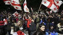 Grúz zászlókat lengető tüntetők gyülekeznek a parlament épülete előtt Tbilisziben. 2024. május 13-án. 