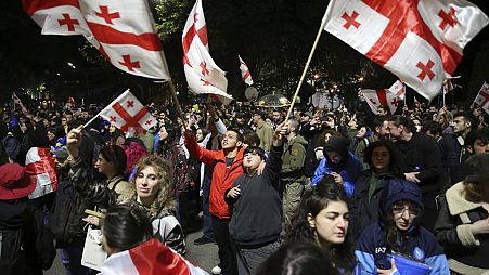 Manifestantes ondeando banderas nacionales georgianas se reúnen frente al edificio del Parlamento durante una protesta contra "la ley rusa" en Tiflis, Georgia. 13 de mayo de 2024. 