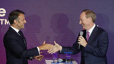  الرئيس التنفيذي لشركة مايكروسوفت براد سميث، يمين، يصافح الرئيس الفرنسي إيمانويل ماكرون في مقر شركة مايكروسوفت بفرنسا - 13 مايو 2024