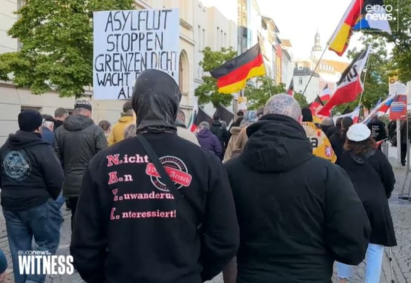 Un gruppo di manifestanti alla Marcia del Lunedí a Gera. Sulla maglietta del dimostrante: "Non interessati all'immigrazione. 100% ariani".  