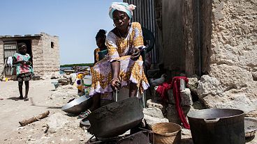 Una mujer tuesta cacahuetes frente a su casa en la isla de Diamniadio, en Senegal.