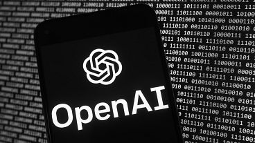  Il logo di OpenAI appare su un telefono cellulare davanti a uno schermo di computer con dati binari casuali, giovedì 9 marzo 2023, a Boston.