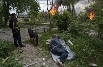 Un hombre yace en el suelo mientras observa su casa en llamas destruida por un ataque aéreo ruso en Vovchansk, Ucrania, el sábado 11 de mayo de 2024.
