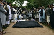 Los cadáveres de afganos son colocados en el suelo después de las fuertes inundaciones en la provincia de Baghlan, en el norte de Afganistán, el 11 de mayo de 2024.