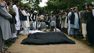 Los cadáveres de afganos son colocados en el suelo después de las fuertes inundaciones en la provincia de Baghlan, en el norte de Afganistán, el 11 de mayo de 2024.