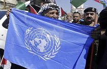 A Palestinian holds U.N flag in a refugee camp near Bethehem, West Bank, Wednesday, Sept. 26, 2018. (AP Photo/Mahmoud Illean)