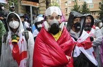 Demonstrators in gas masks stand near the Parliament building during an opposition protest against "the Russian law" in the center of Tbilisi, Georgia, on Monday, May 13, 2024