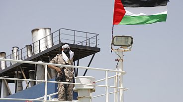 جندي حوثي يقف على متن سفينة جالاكسي الإسرائيلية التي استولى عليها الحوثيون