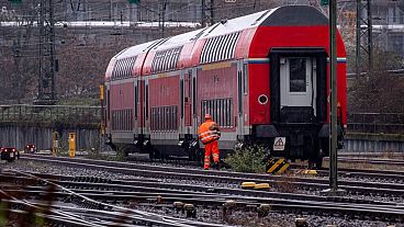 عامل سكة حديد يمر بجانب قطار متوقف خارج محطة القطارات المركزية في فرانكفورت، ألمانيا ـ أرشيف