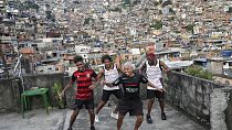 Jovens fazem o "passinho" para as suas contas nas redes sociais na favela da Rocinha, no Rio de Janeiro, Brasil, a 17 de abril de 2024.