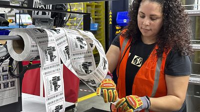 An employee prepares online orders in a distribution center.