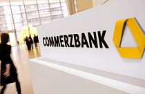In this Dec. 4, 2011 file picture a person passes the logo of German Commerzbank in Frankfurt, Germany.