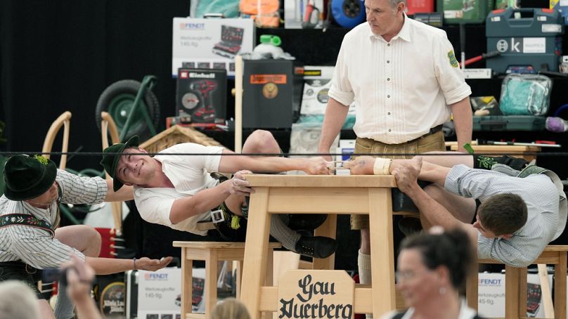 Un árbitro supervisa el anillo de cuero que sostienen dos competidores con el dedo corazón en los Campeonatos de Alemania de Fingerhakeln en Bernbeuren, Alemania, 12 de mayo.
