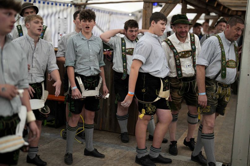 Competidores en trajes tradicionales calientan para sus combates en los Campeonatos de Alemania en Fingerhakeln en Bernbeuren, Alemania, 12 de mayo de 2024.