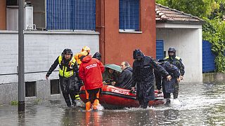 Firefighters use a dinghy boat to evacuate people after part of the city was flooded following persistent rains, in Milan, Italy, Wednesday, May 15, 2024.