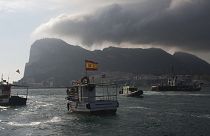 Fishermen on their fishing boat try to reach Gibraltar, in the background, as British and Spanish patrol boats block their access during a protest 