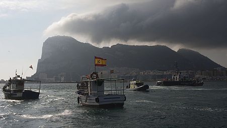 Fishermen on their fishing boat try to reach Gibraltar, in the background, as British and Spanish patrol boats block their access during a protest 