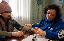 Un volontaire médical de FRIDA Ukraine examine la tension artérielle d'un patient.