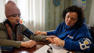Un volontaire médical de FRIDA Ukraine examine la tension artérielle d'un patient.