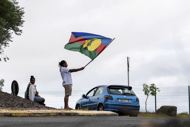 Une femme brandit un drapeau du Front de libération nationale kanak et socialiste (FLNKS) à Nouméa, en Nouvelle-Calédonie.