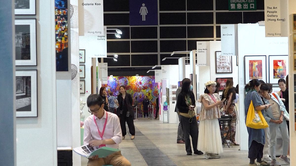 Visitors look at artworks at the "Affordable Art Fair" in Hong Kong