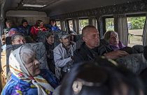 People sit in a bus after evacuation from Vovchansk,