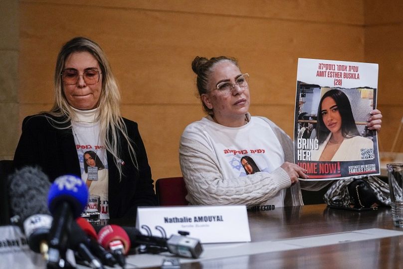 Alin Atias, a la derecha, sostiene una fotografía de su hija Amit Buskila durante una rueda de prensa en febrero de 2024.
