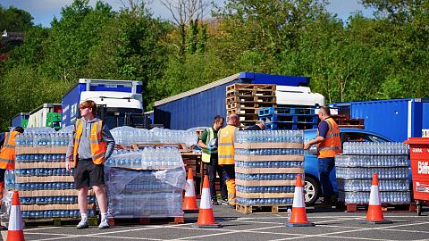 People collect bottled water at Broadsands Car Park in Paignton, England, Friday 17 May 2024. 