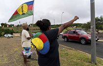 A woman waves a Kanak and Socialist National Liberation Front (FLNKS) flag in Noumea, New Caledonia, Wednesday May 15, 2024.