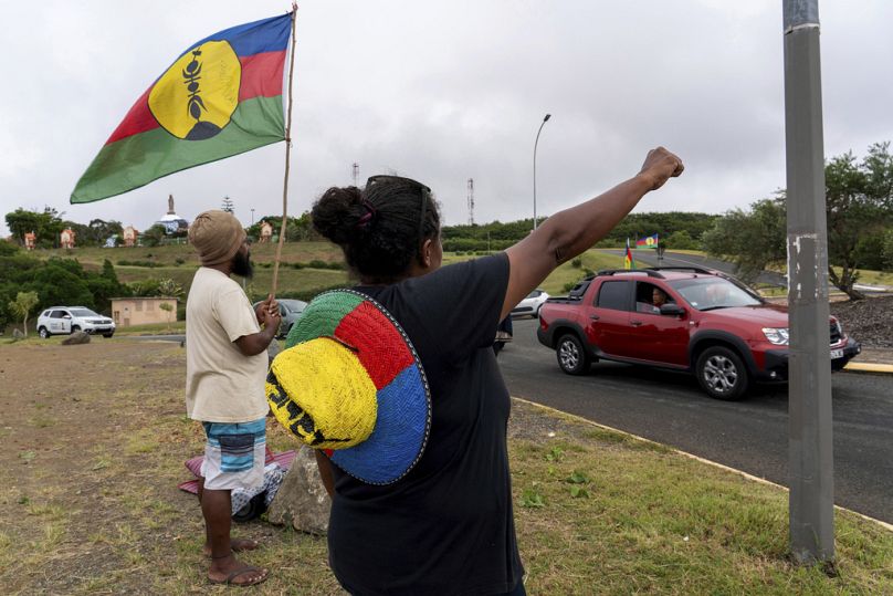 Une femme brandit un drapeau du Front de libération nationale kanak et socialiste (FLNKS) à Nouméa, en Nouvelle-Calédonie.