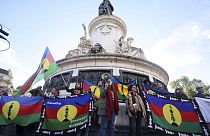 Demonstrators hold Kanak and Socialist National Liberation Front (FLNKS) flags during a gathering in Paris