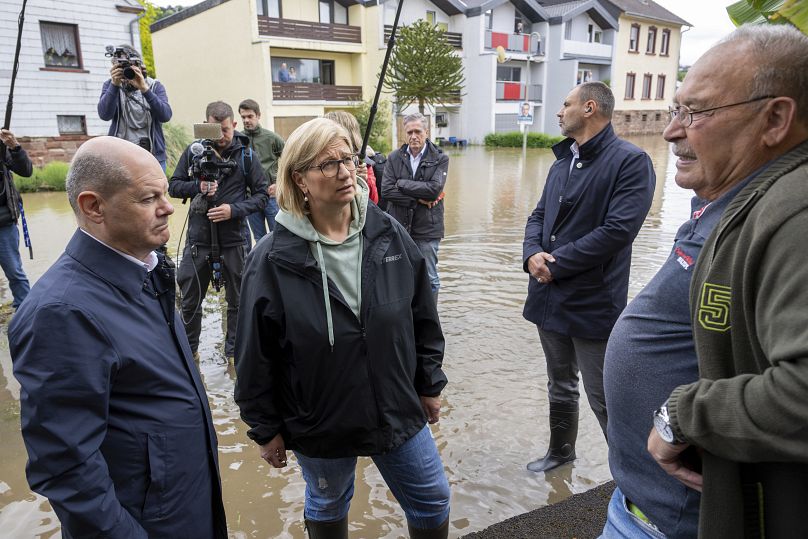 German Chancellor Olaf Scholz, left and Minister President Anke Rehlinger speak to local residents as they visit Kleinblittersdorf, Germany, Saturday, May 18, 2024.