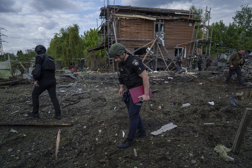 Ukrainische Polizisten suchen nach Fragmenten einer Gleitbombe nach einem russischen Luftangriff auf ein Wohnviertel in Charkiw, 18. Mai 2024