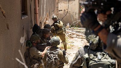 مجموعة  من الجنود الإسرائيليين يحتمون خلف جدار في غزة