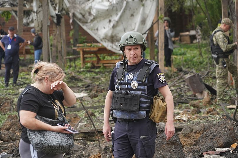 A woman cries as police inspect the site of the Russian missile attack that hit a recreation area, killing five people, in the outskirts of Kharkiv, Sunday, May 19, 2024.