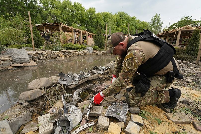 A sapper inspects fragments of Russian missiles that hit a recreation area killing five and injuring 16 in the outskirts of Kharkiv, Ukraine, Sunday, May 19, 2024.