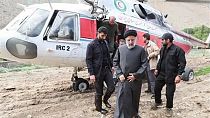 الرئيس الإيراني إبراهيم رئيسي وعدد من مرافقيه وخلفهم المروحية التي استقلوها