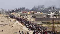 فلسطينيون ينتظرون عبور شاحنات المساعدات في وسط قطاع غزة