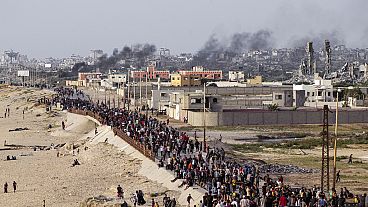 فلسطينيون ينتظرون عبور شاحنات المساعدات في وسط قطاع غزة