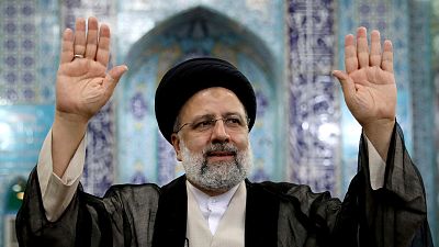 Ebrahim Raisi waves to the media after casting his vote at a polling station during Iran's presidential elections in Tehran, 18 June 2021