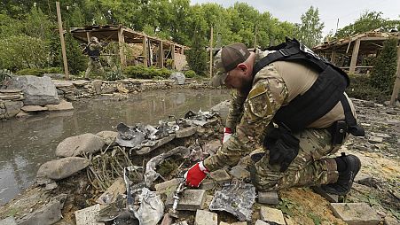 A sapper inspects fragments of Russian missiles that hit a recreation area killing five, and injuring 16, in the outskirts of Kharkiv, Ukraine, Sunday, May 19, 2024.