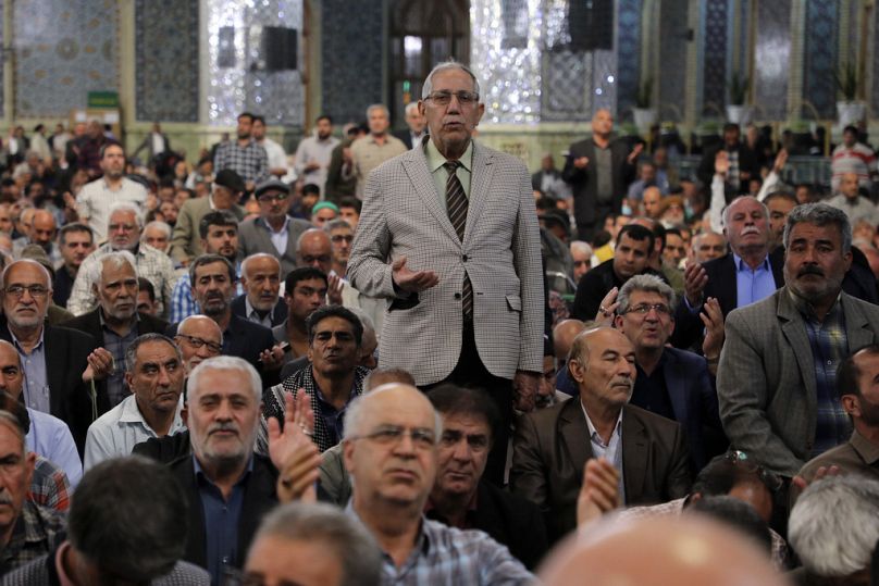 Peregrinos rezam pelo Presidente iraniano Ebrahim Raisi no Santuário Imam Reza, na cidade de Mashhad