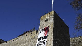 Un cartello con l'immagine del presidente russo Vladimir Putin fuori dal castello di Narva, in Estonia, 9 maggio 2023