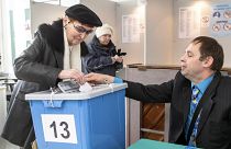 Un empleado de la comisión electoral ayuda a una mujer a emitir su voto en un colegio electoral en Tallin, Estonia, el 3 de marzo de 2019.