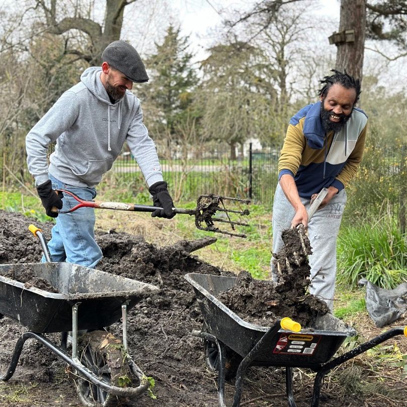 Imagen de dos ciudadanos realizando labores de jardinería en el huerto del Museo de los Sintecho.