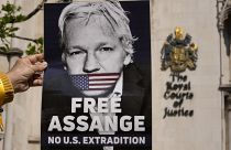 متظاهر يحمل ملصقًا لمؤسس ويكيليكس جوليان أسانج خارج المحكمة العليا في لندن