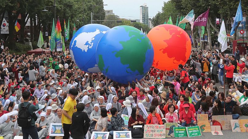 Climate activists carry Earth balloons during a rally demanding action in halting the climate crisis in Seoul, South Korea, September 2019.