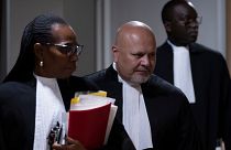 DATEI - Staatsanwalt Karim Khan, Mitte, betritt den Gerichtssaal für den Prozess gegen Mahamat Said Abdel Kani am IStGH in Den Haag, Niederlande, Montag, 26. September 2022.