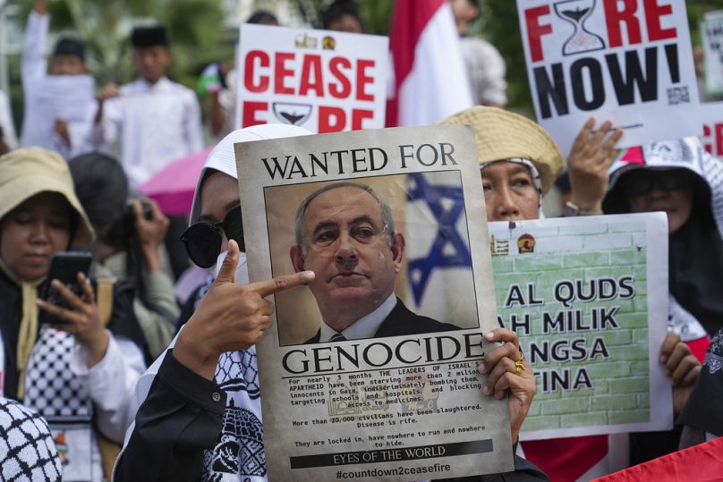 Un manifestante tiene in mano un poster del primo ministro israeliano Benjamin Netanyahu durante una manifestazione per commemorare il 76° anniversario della "Nakba"